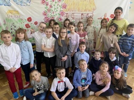 Uczniowie i wychowawca na grupowym zdjęciu w sali lekcyjnej