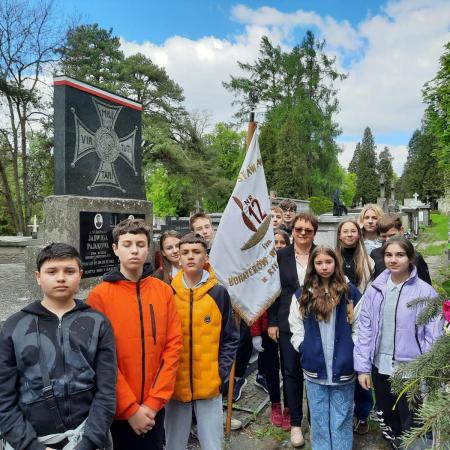 Uczniowie SP12 ze sztandarem szkoły na cmentarzu przy grobie poległych za ojczyznę.