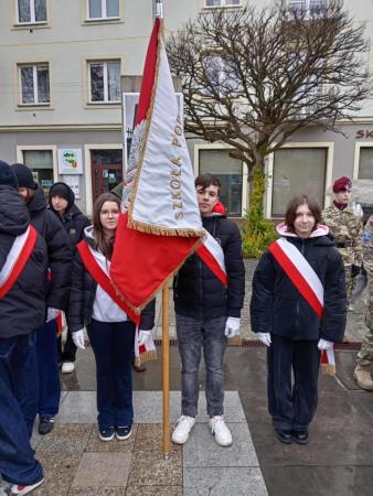 Uczniowie trzymający sztandar szkoły