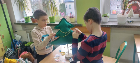 uczniowie szyjący choinkę