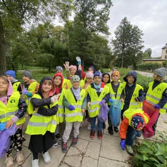 Uczniowie SP12 podczas akcji sprzątania świata pozują w rzędzie do zdjęcia.