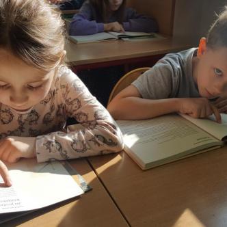 Uczniowie klasy 1 b czytają ksiązki podczas akcji "Przerwa na czytanie".