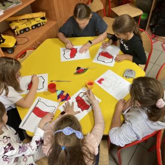 Uczniowie świetlicy wykonujący prace plastyczne o tematyce patriotycznej