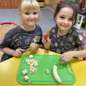 uczennice przygotowujące sałatkę owocową